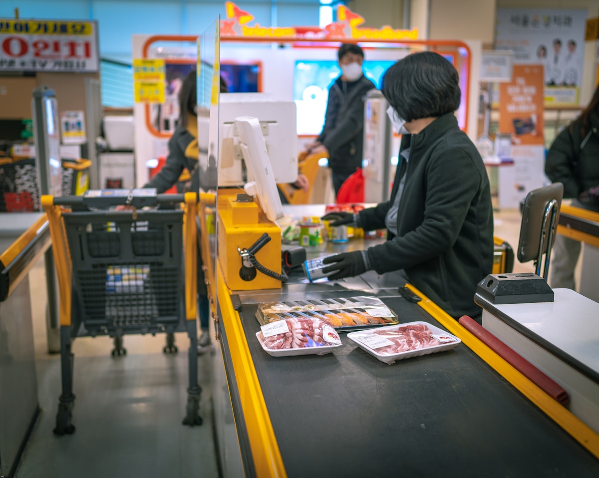 Cashier scanning items at a retail checkout lane